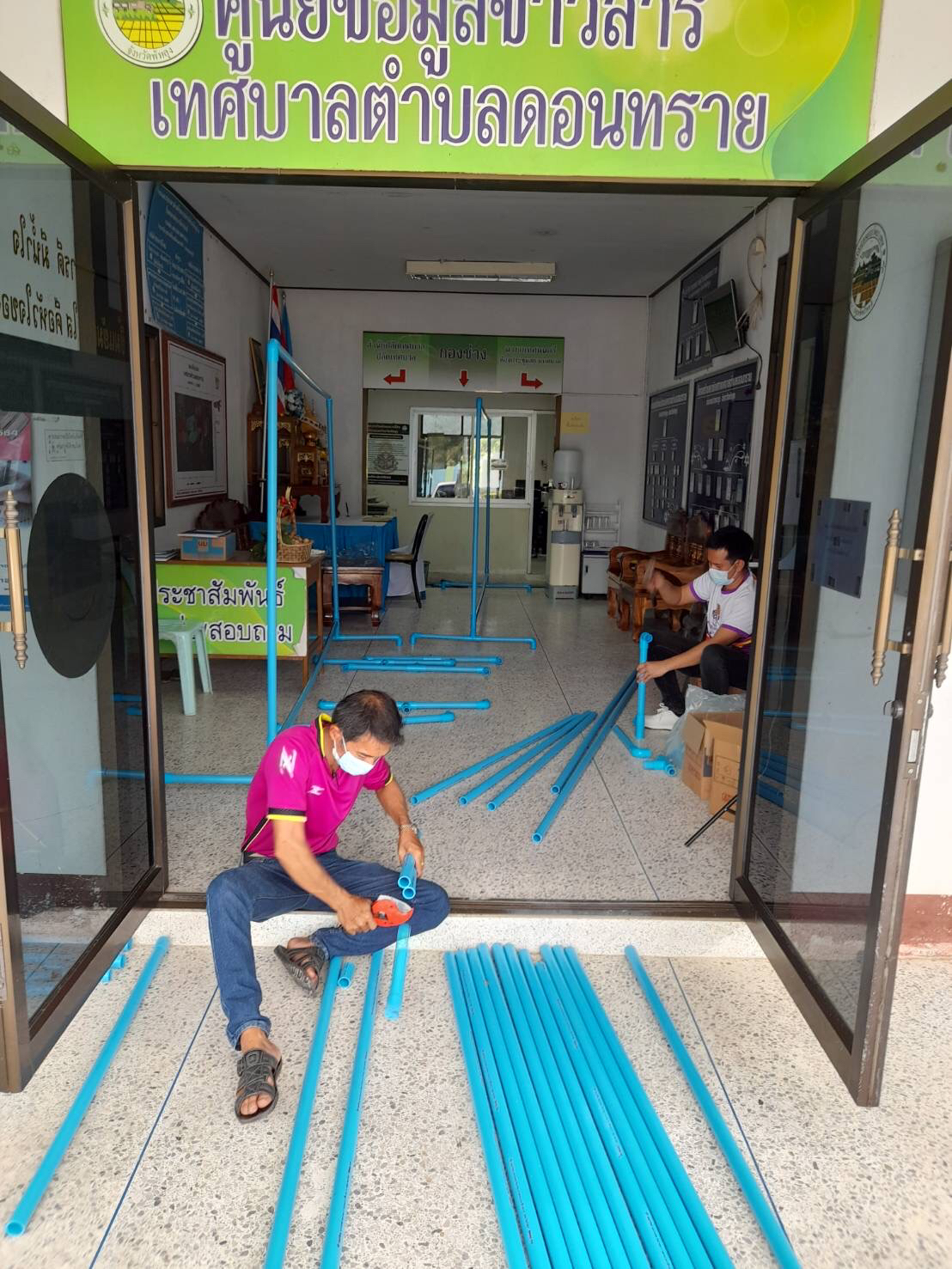 พนักงานกองช่างจัดทำแผงสำหรับกั้นห้องผู้กักตัว ณ ศูนย์คัดแยกกักตัวชุมชน LQ